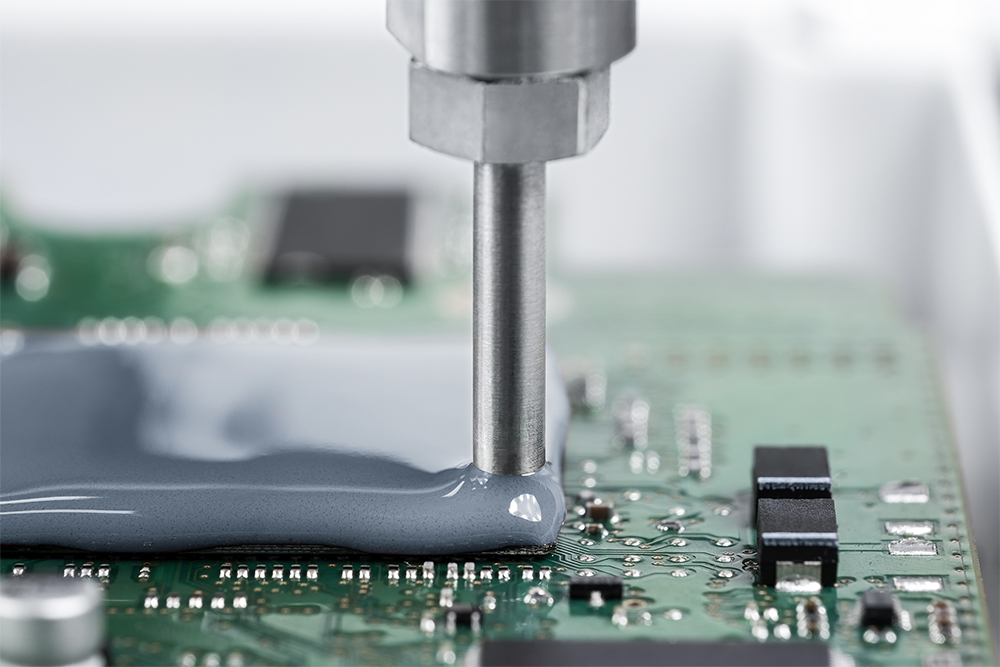 Applying an epoxy resin coating to a circuit board.